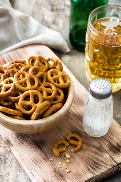 Pretzels en tazón y cerveza en mesa de madera