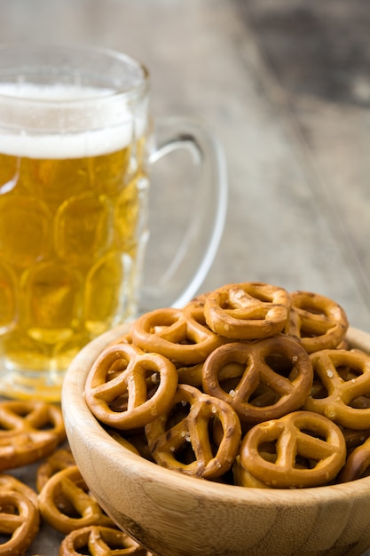 Pretzels en tazón y cerveza en mesa de madera