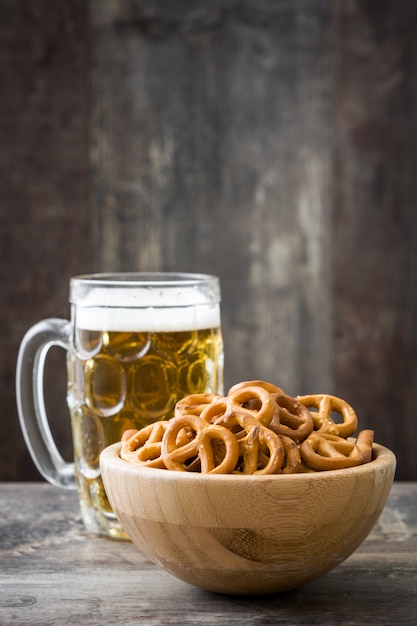 Pretzels en tazón y cerveza en mesa de madera