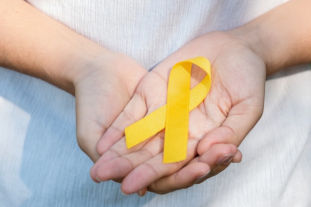 Prevenção de suicídio, sarcoma, osso, bexiga, mês de conscientização do câncer infantil, fita amarela para apoio a pessoas que vivem e adoecem. conceito do dia mundial da saúde das crianças e do câncer