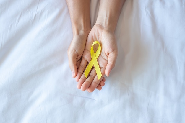 Prevención del suicidio, sarcoma, hueso, vejiga, mes de concientización sobre el cáncer infantil, cinta amarilla para apoyar a las personas que viven y están enfermas. Concepto de salud infantil y día mundial contra el cáncer.