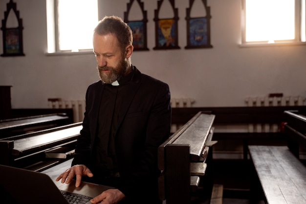 Priester mit Laptop hautnah