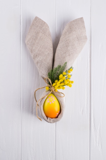 Primavera fondo de Pascua para el menú. Decoración de huevos de Pascua, servilletas de lino y cubiertos de cocina en la mesa de madera blanca