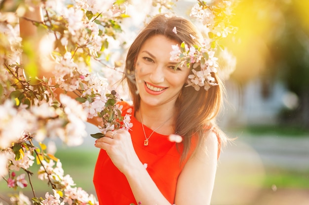 Primavera mujer hermosa cara femenina disfrutando de los cerezos en flor.