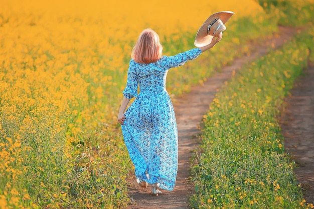 primavera natureza jovem em um campo de flores, liberdade e felicidade de uma senhora em uma paisagem ensolarada