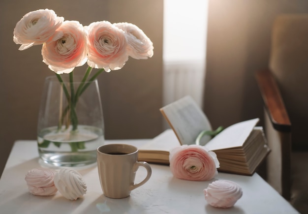 Primavera romántica naturaleza muerta con flores, taza de café, un libro y malvaviscos