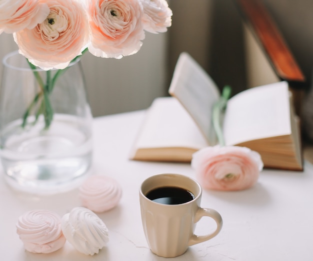 Primavera romántica naturaleza muerta con flores, taza de café, un libro y malvaviscos