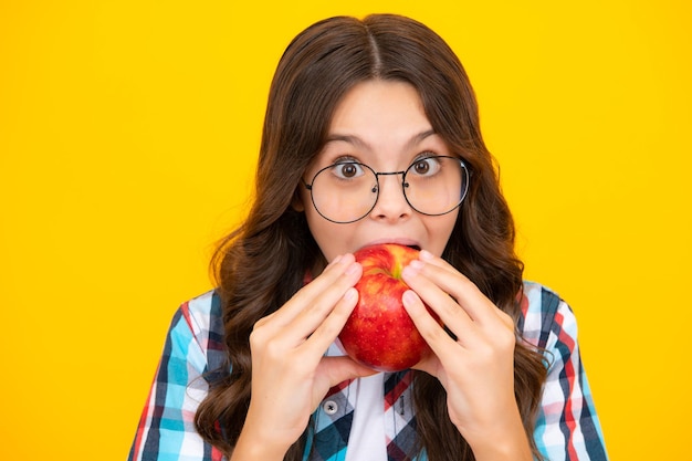 Foto primavera en todas partes temporada de primavera frutas llenas de vitaminas alimentos orgánicos solo natural y saludable infancia feliz niño comer manzana niño con fruta sorprendida niña adolescente sorprendida