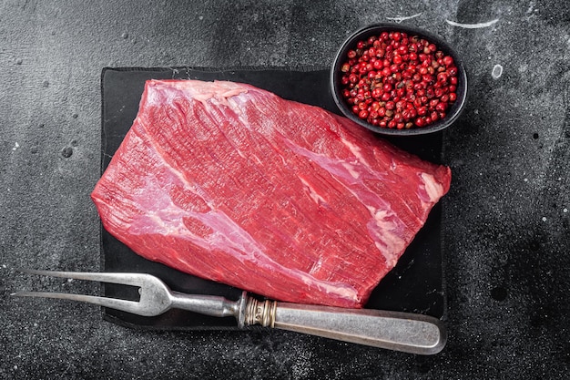 Prime Choice Flankensteak rohes Rindfleisch auf Marmorplatte mit Kräutern Schwarzer Hintergrund Draufsicht