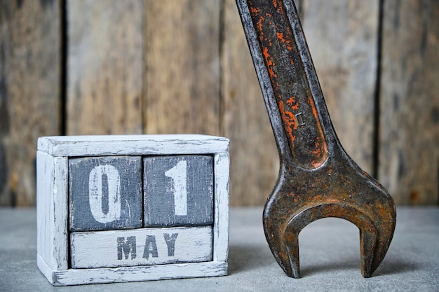 Primeiro de maio no calendário feito de madeira e chave inglesa no backgroundConcept Dia do Trabalho