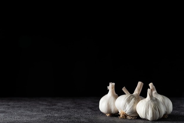 Foto primer ajo en textura de piedra. ajo para cocinar sobre fondo oscuro.