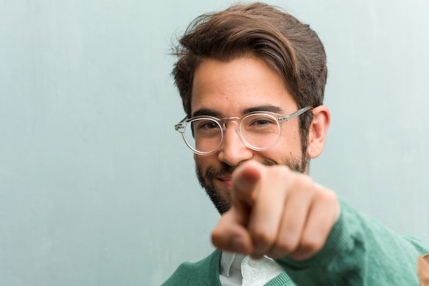 Primer apuesto joven de la cara del hombre del empresario alegre y que sonríe señalando al frente