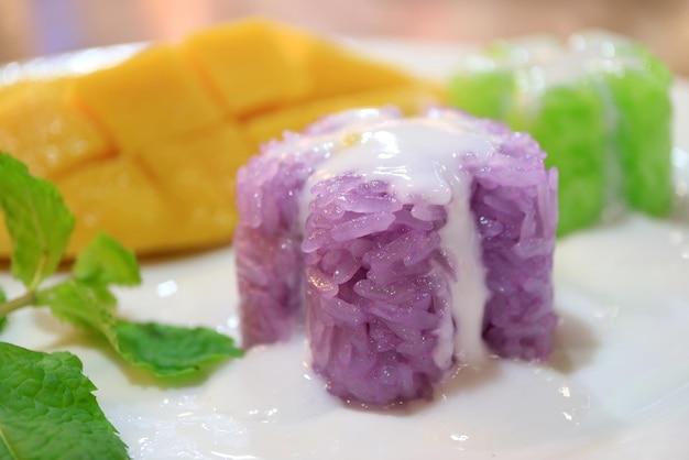 Primer arroz pegajoso púrpura tailandés popular con leche de coco cremosa y mango maduro fresco