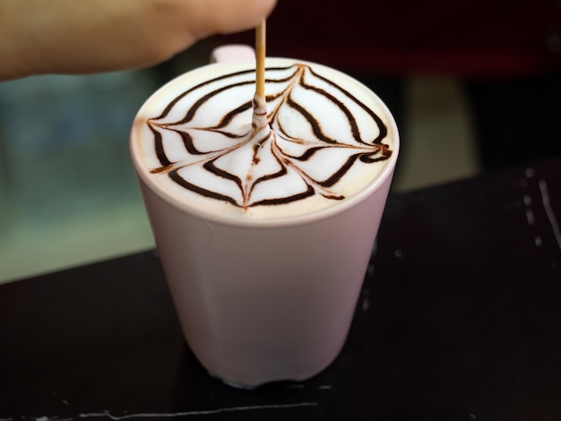 Primer arte latte casero en una taza de café en el cuadro negro