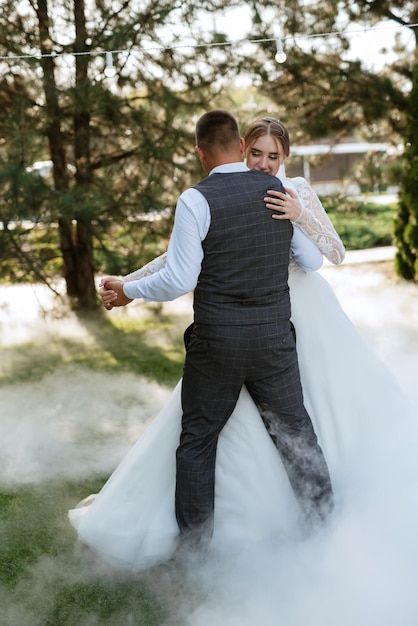 El primer baile de bodas de la novia y el novio en un prado verde