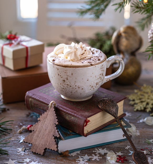 Primer blanco taza de café en la mesa festiva y cajas de regalo sobre fondo de madera. Navidad o año nuevo