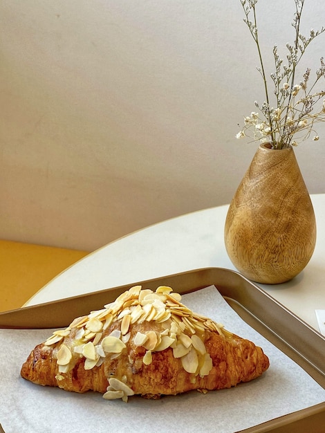 Primer croissant de almendras en mesa blanca