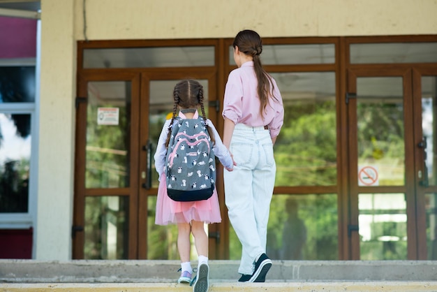 Primer día en la escuela La hermana mayor lleva a una colegiala en primer grado Regreso a la escuela