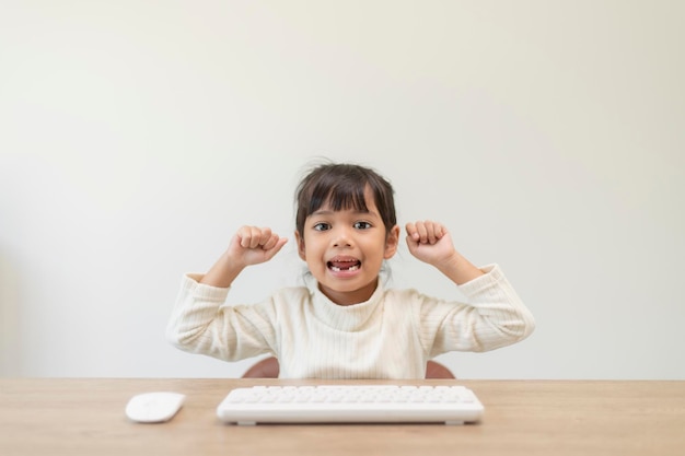 Primer día en la escuela Niñas lindas que usan una computadora portátil y estudian a través del sistema de aprendizaje electrónico en línea