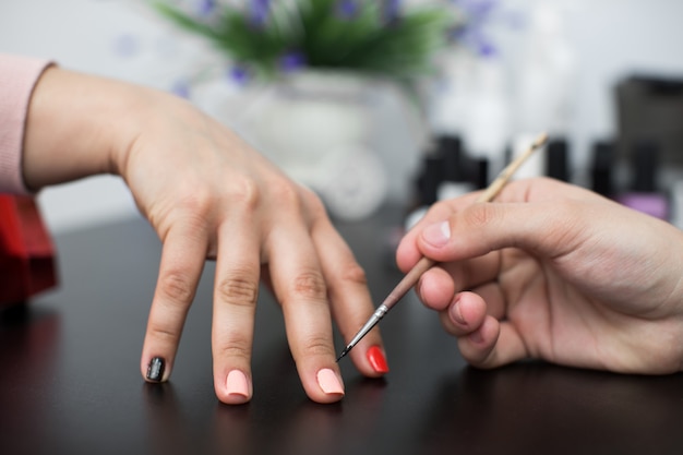 Primer disparo hombre haciendo manicura a mujer en salón de belleza