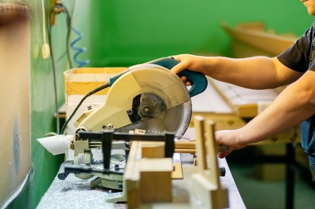 Primer ebanista cortando tablero de madera con sierra circular eléctrica en aserradero de carpintería Ebanista profesional utiliza sierra circular en fábrica de aserradero Producción de muebles de madera Carpintería