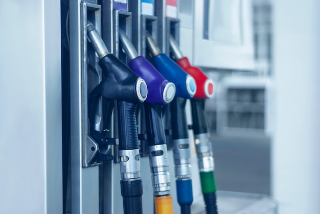 Foto primer de la gasolinera con las mangueras de combustible coloreadas.
