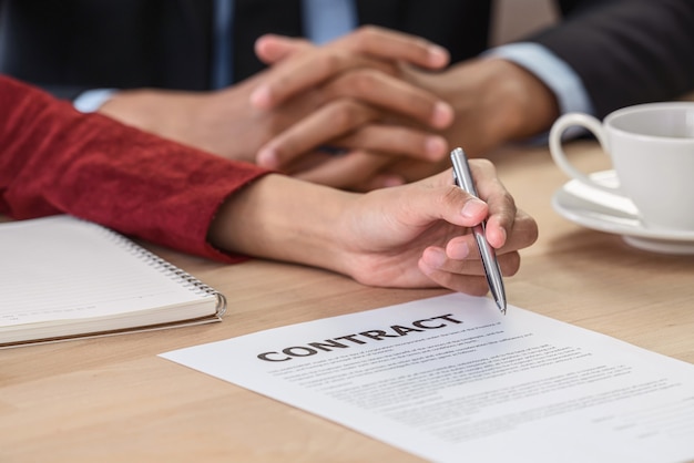 Foto primer graduado de la mujer asiática joven firmando el contrato después de la entrevista de trato