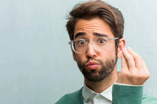 Primer hermoso joven de la cara del hombre del empresario que hace un gesto italiano típico