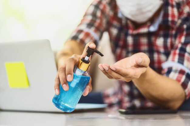 Primer hombre asiático con desinfectante de manos bombeando gel de alcohol y lavado