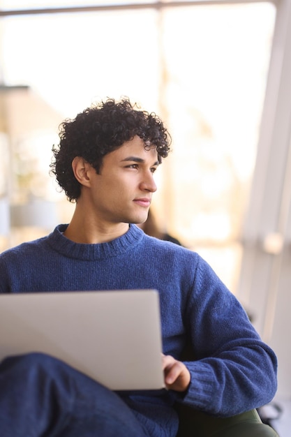 Primer hombre hispano que trabaja en línea en el razonamiento de la computadora portátil en sus planes de negocios y proyecto de inicio