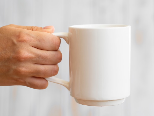 Primer hombre sosteniendo la taza blanca