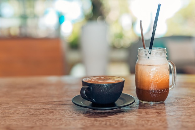 Primer idílico de la mañana, cafetería, bar. Mesa de madera con café helado y café con leche. Motivacional