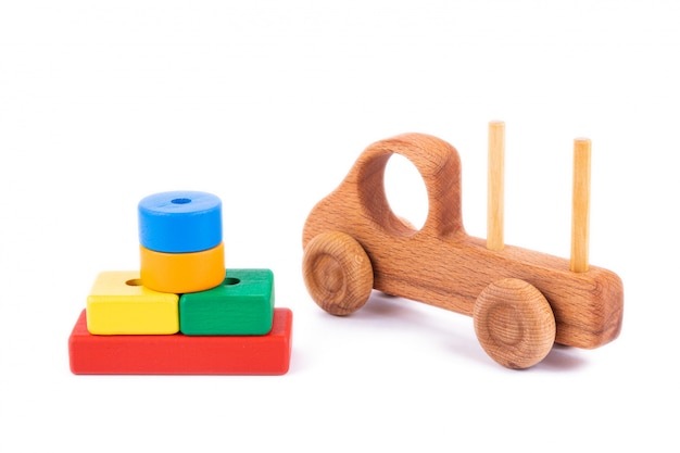 Primer juguete para niños hecho de madera natural en forma de camión volquete con bloques de madera en forma de formas geométricas multicolores en blanco