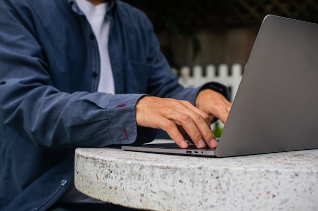 Primer mano escribiendo en el teclado de la computadora trabajar en casa