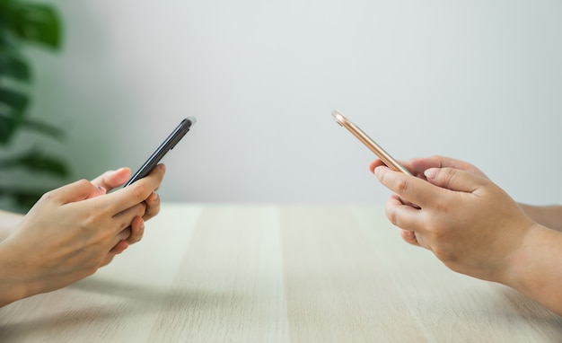 Foto primer de la mano que sostiene el dispositivo del smartphone y que escribe el mensaje de texto en social en línea.