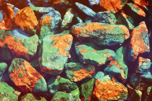 Primer piedra empapada en pintura naranja, azul y verde