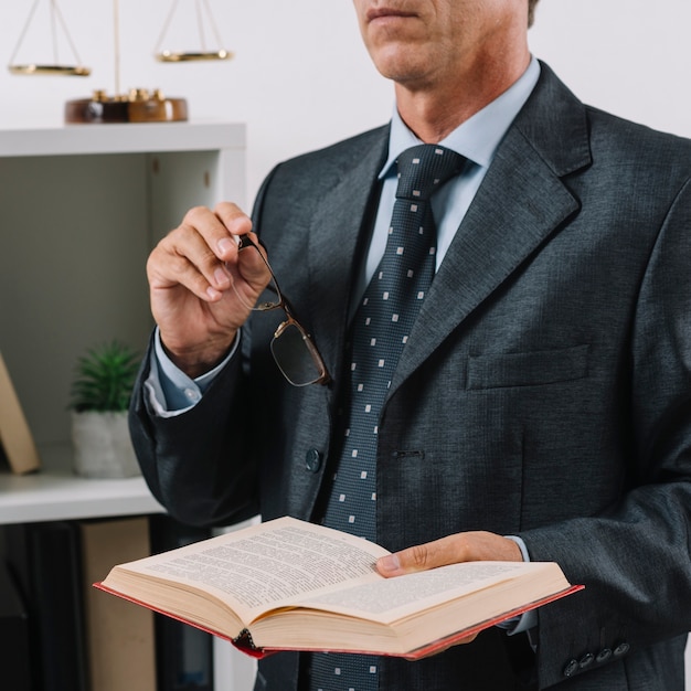 Primer plano de abogado hombre sosteniendo un libro legal en la mano