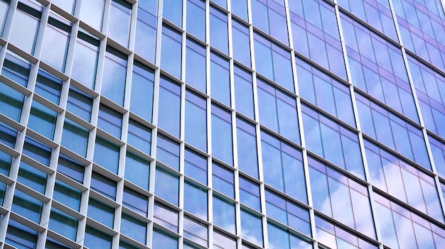 Primer plano abstracto de la fachada acristalada de un edificio moderno cubierto con vidrio de placa reflectante