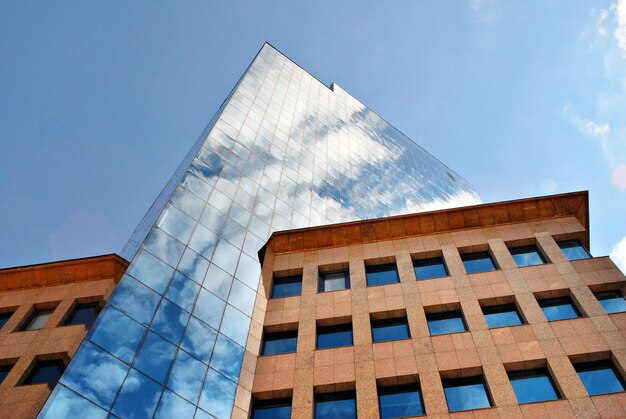 Primer plano abstracto de la fachada revestida de vidrio de un edificio moderno cubierto de vidrio de placa reflectante