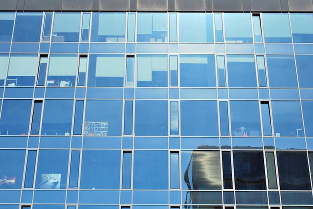 Primer plano abstracto de la fachada de vidrio de un edificio moderno cubierto de vidrio de placa reflectante.