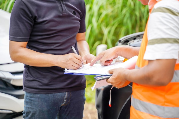 Primer plano y accidente de tráfico de cultivos y agente de seguros que trabaja en el formulario de informe con el proceso de reclamación de accidentes automovilísticos en el fondo borroso