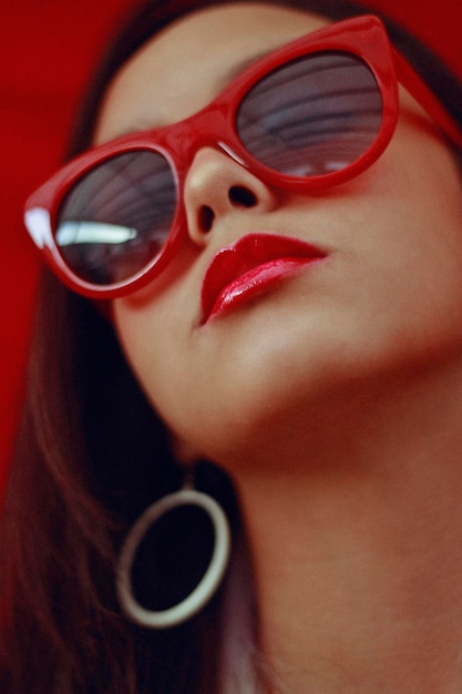 Primer plano de una adolescente con gafas de sol rojas