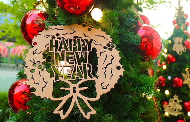 Primer plano de un adorno de FELIZ AÑO NUEVO colgado en el árbol de Navidad