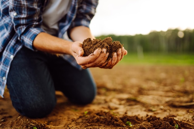 Primer plano de un agricultor con las manos fuertes en un campo negro Concepto de ecología de jardinería