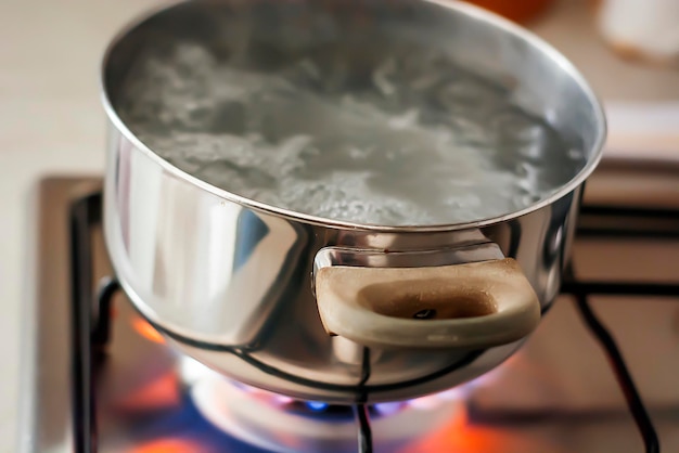 Primer plano del agua hirviendo en el recipiente en la estufa