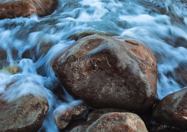 Foto primer plano del agua que fluye a través de las rocas