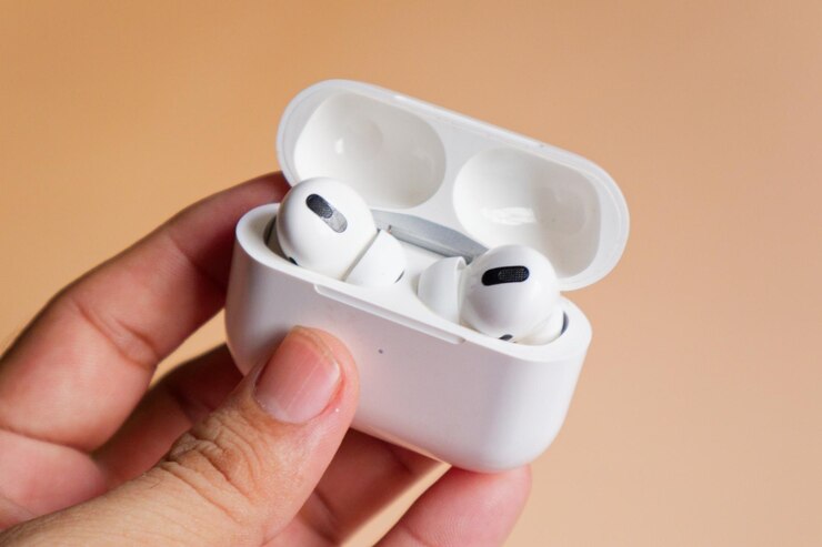 Un primer plano de AirPods blancos en una mano que muestra el epítome del estilo y la comodidad