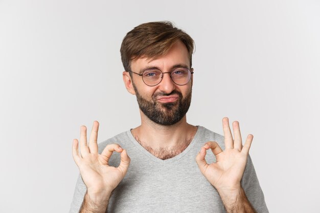 Primer plano de alegre hombre caucásico con barba, gafas y camiseta casual