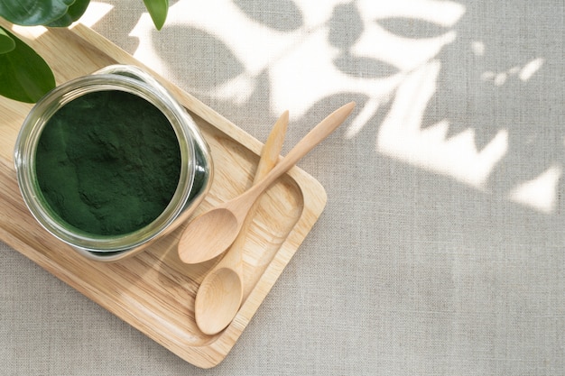 Primer plano de algas microscópicas de color verde azulado: polvo de espirulina en un frasco de vidrio, es un excelente suplemento dietético para una dieta vegana, vegetariana o vegetal porque contiene multivitaminas que incluyen B12.