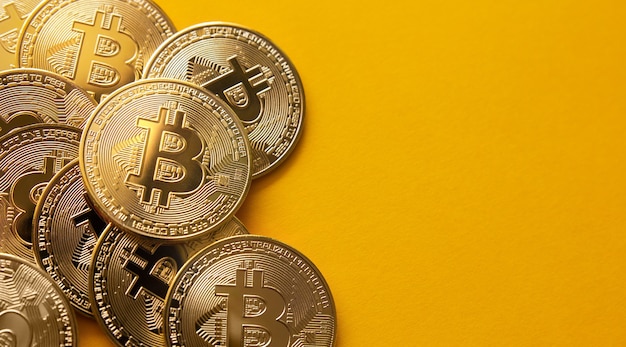 Primer plano de algunos bitcoins sobre un fondo amarillo y copie el espacio